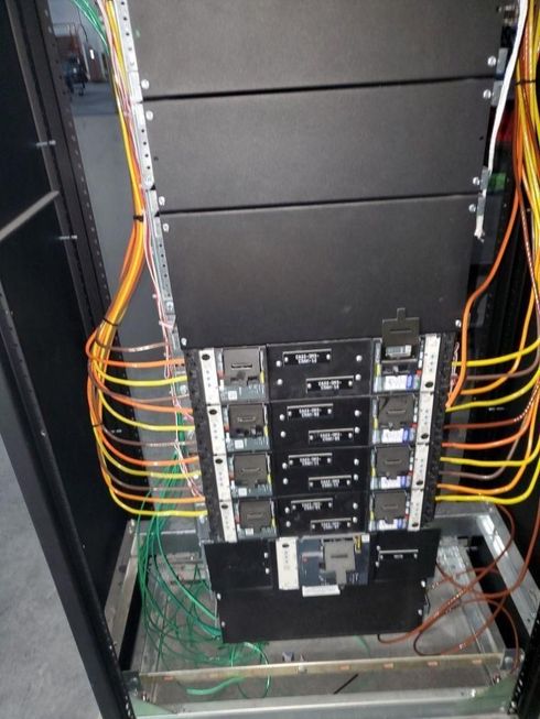 Server rack with network cables and hardware modules inside a cabinet