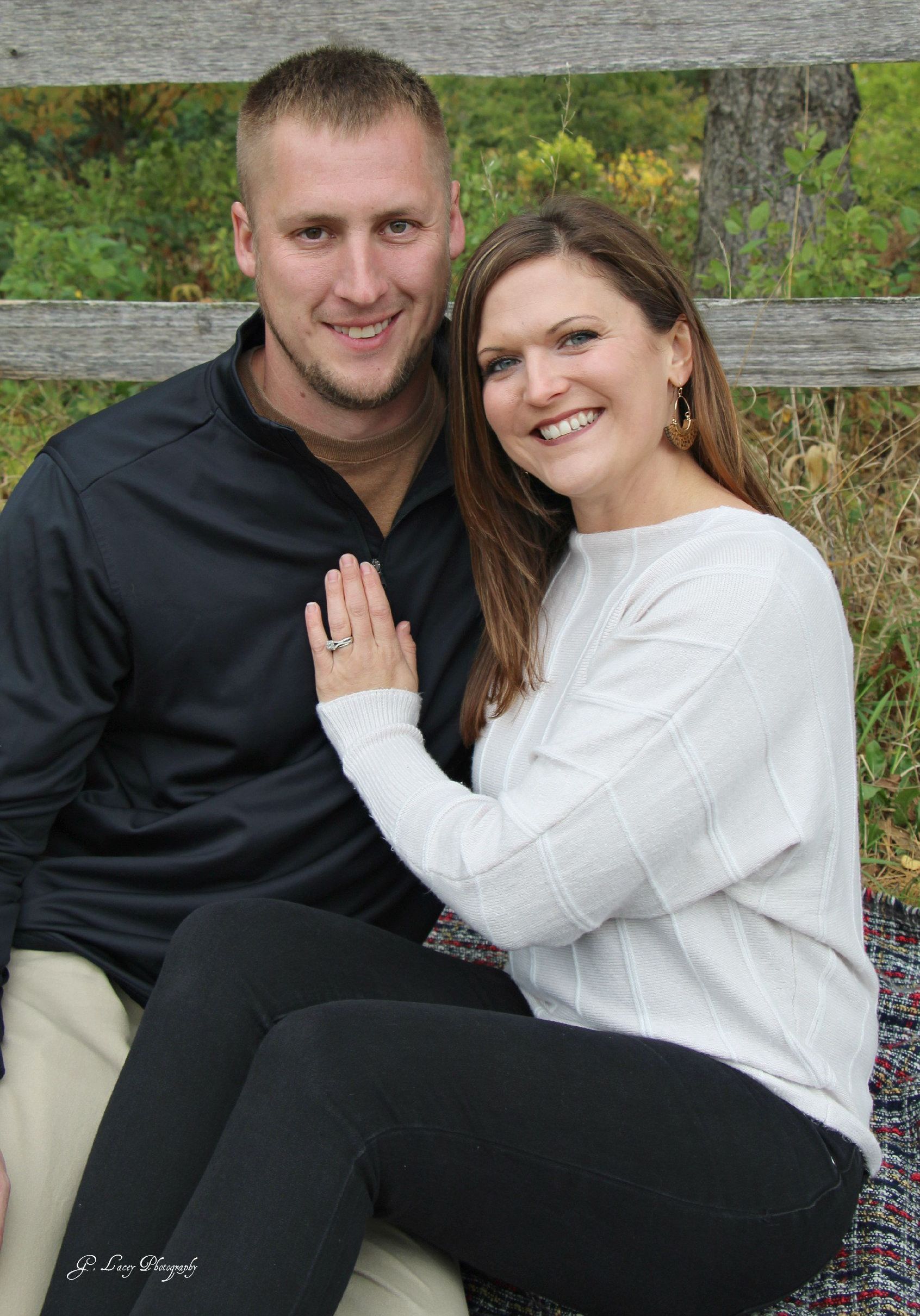 A man and a woman are sitting next to each other on a blanket.