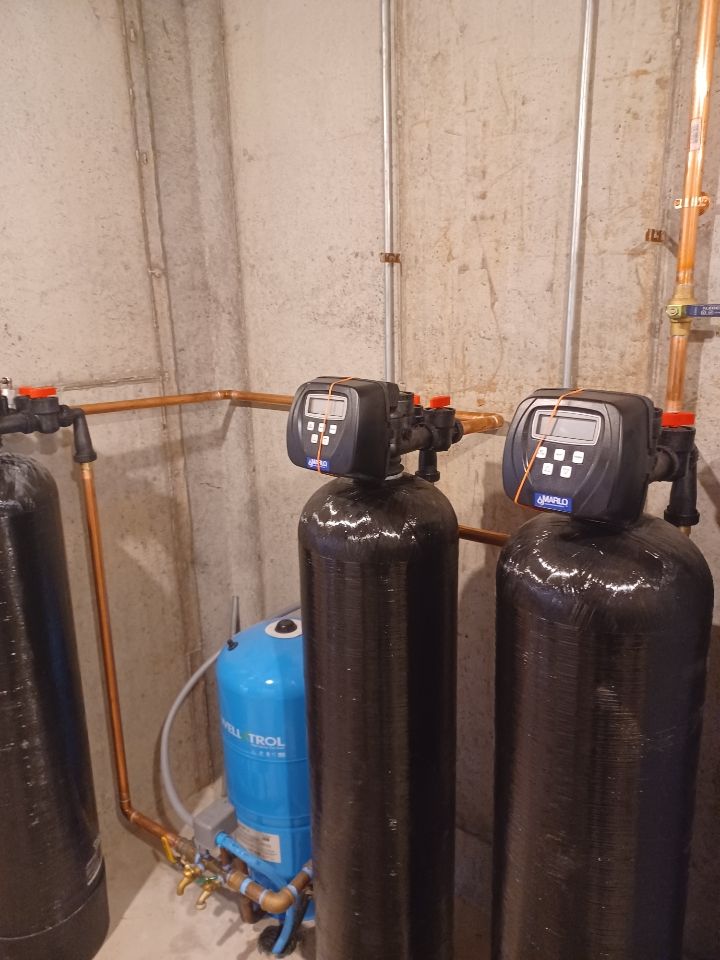 Two water filters are sitting next to each other in a room.