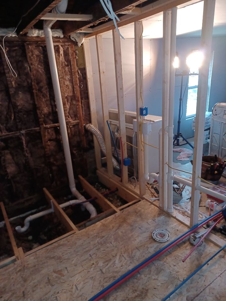 A room is being remodeled with a lot of pipes coming out of the wall.