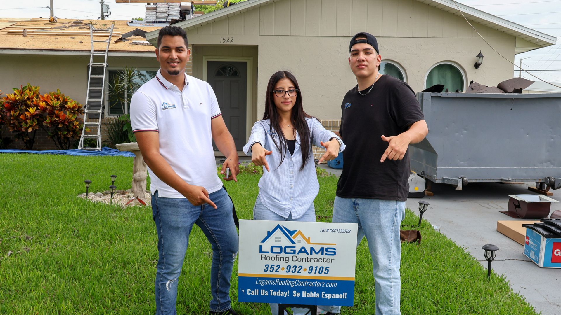 Three people pointing at a sign for