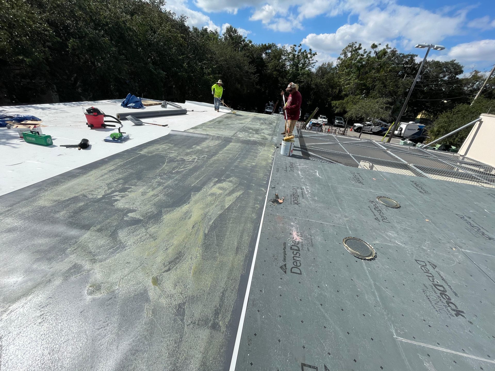 People on a flat roof, working on a construction project on a sunny day.