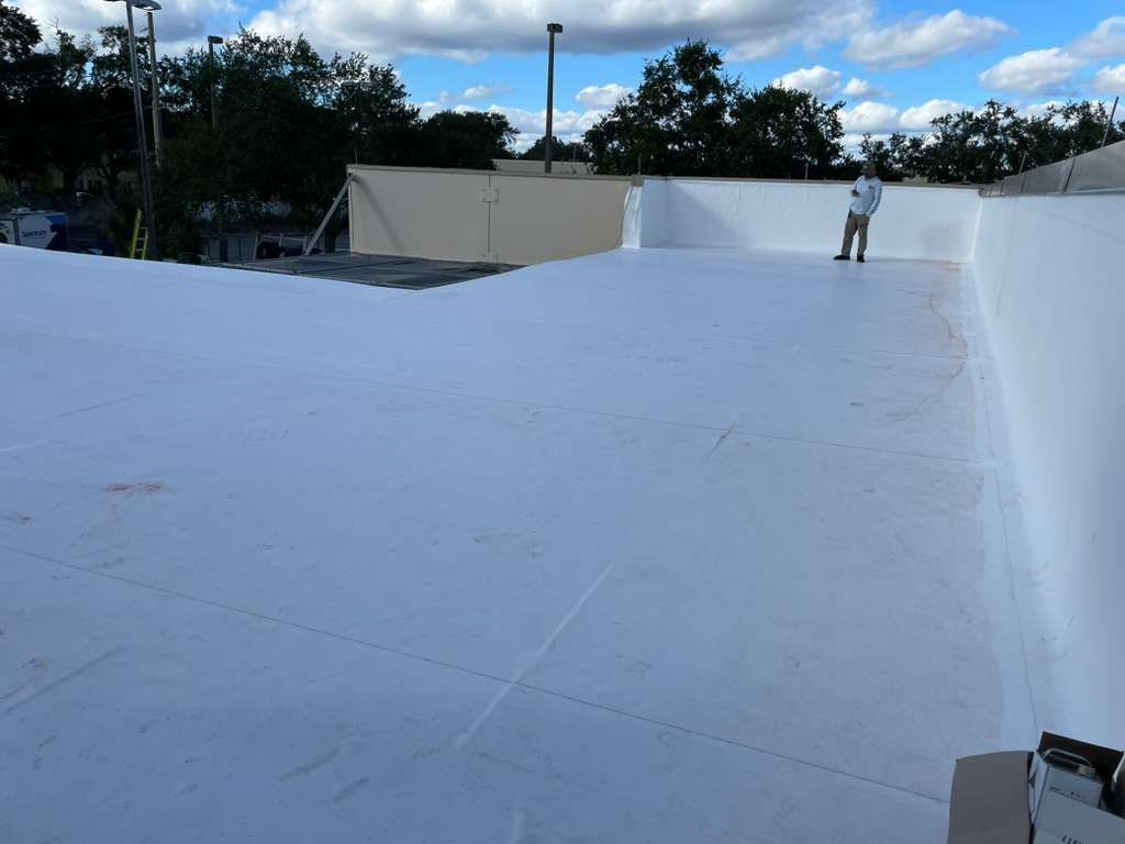 White roof with a person standing on it under a cloudy sky.