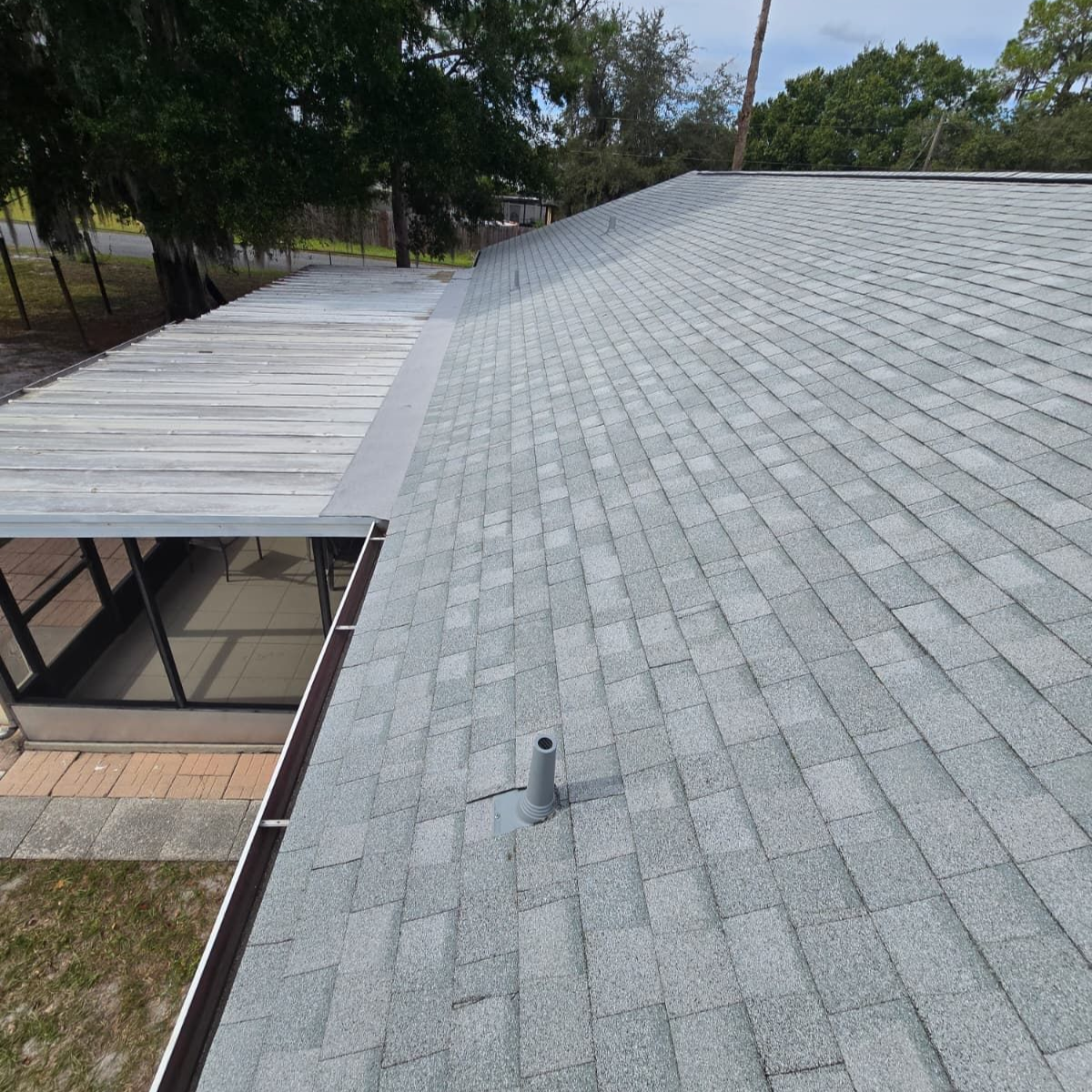 Gray shingle roof on a house with an attached patio, sunny day.
