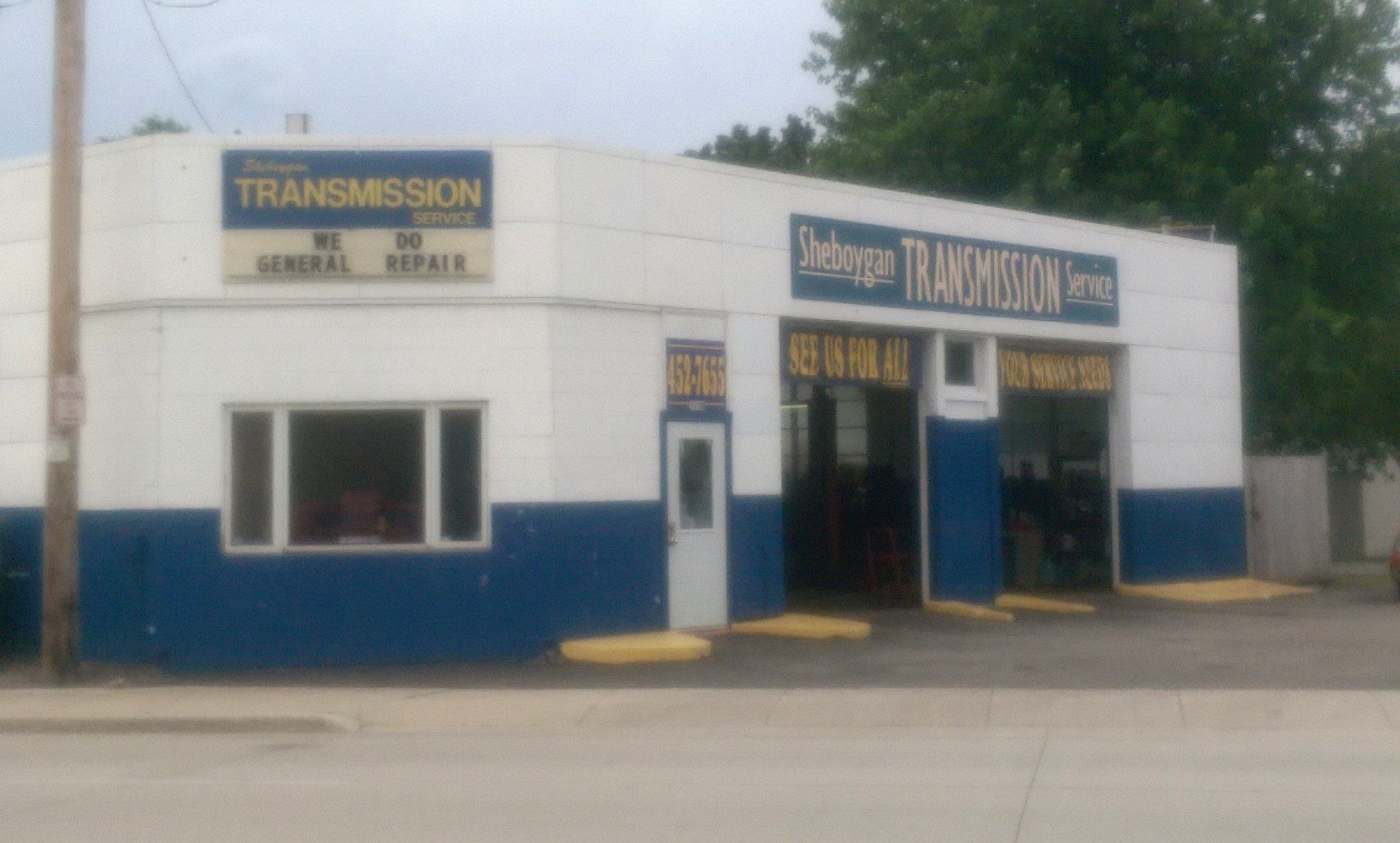 Auto repair shop exterior with blue-and-white facade and transmission service signs