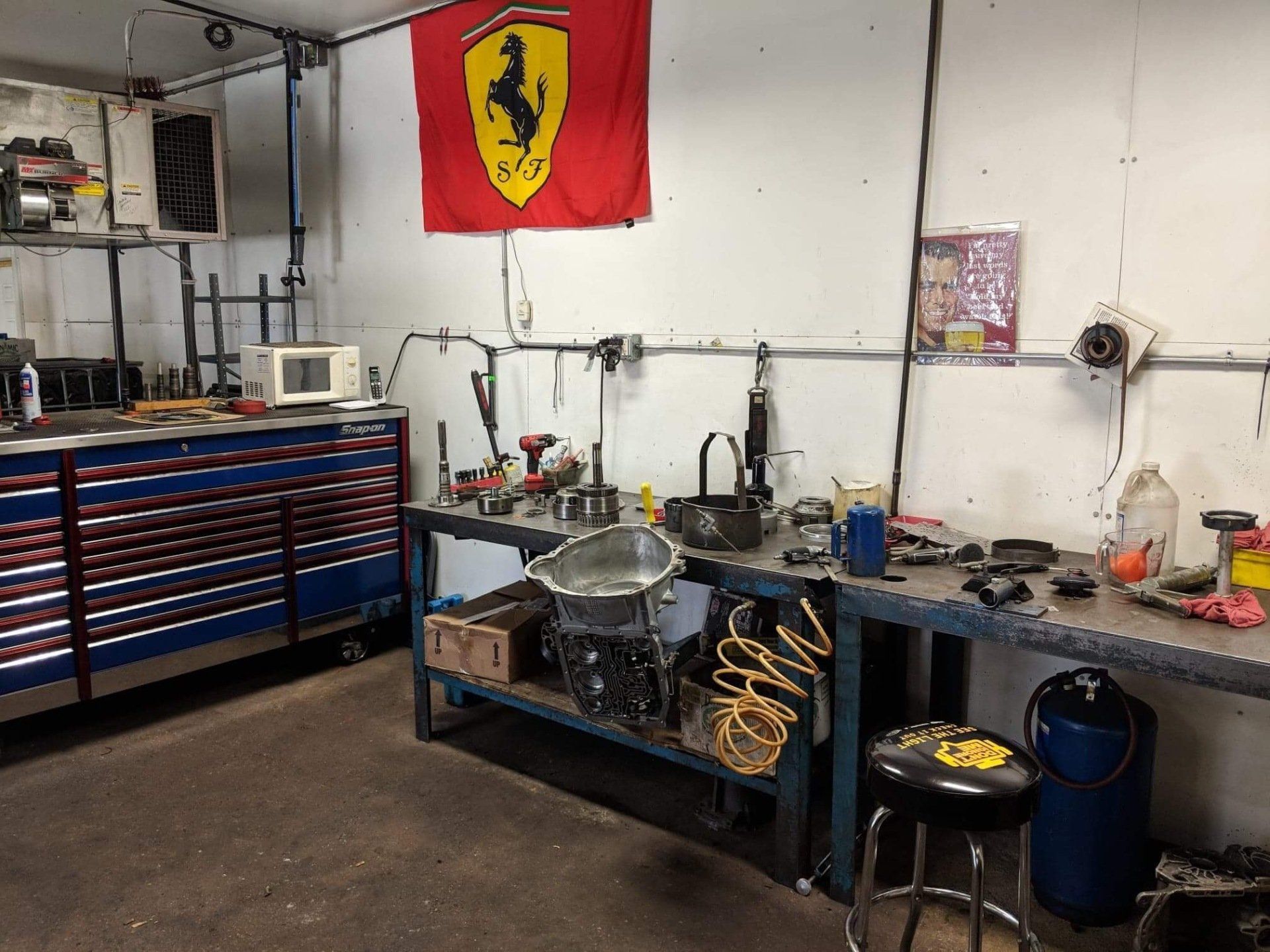 Garage workshop with tool chest, workbench, and Ferrari flag on the wall