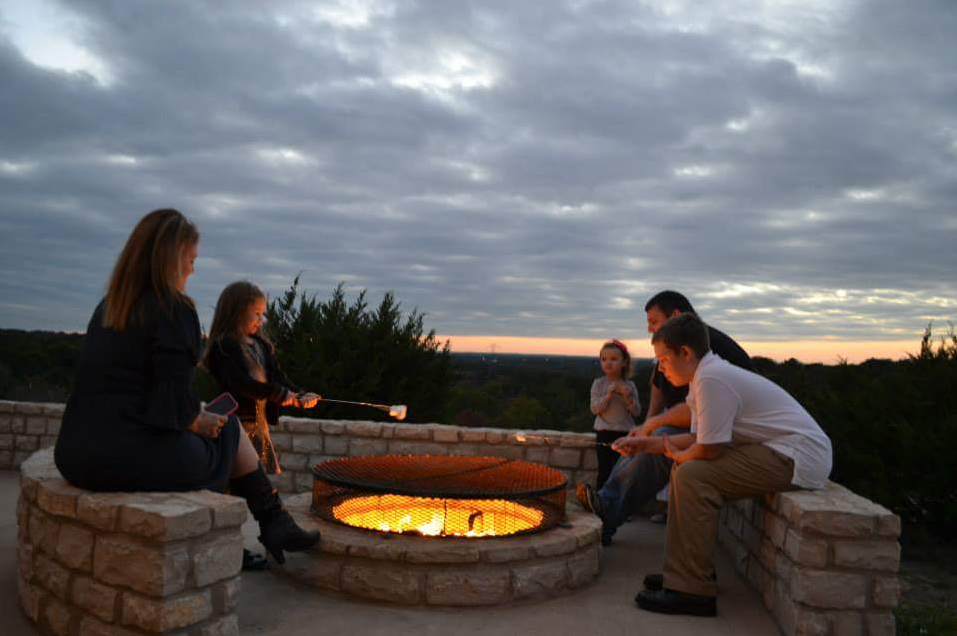 A group of people are sitting around a fire pit.