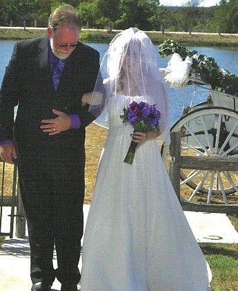 A bride is walking down the aisle with her father