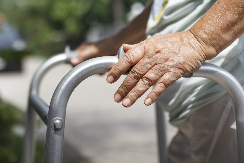 senior woman using a walker cross street