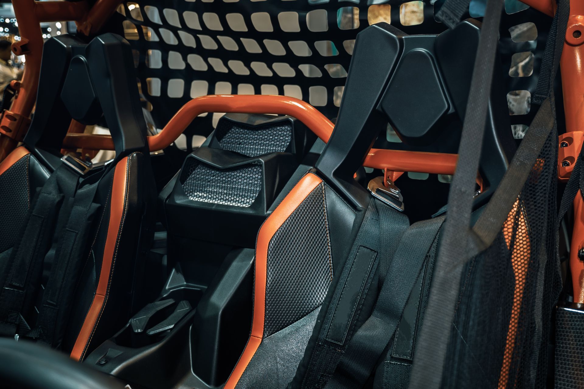Black and orange race car seats with harnesses inside a vehicle interior