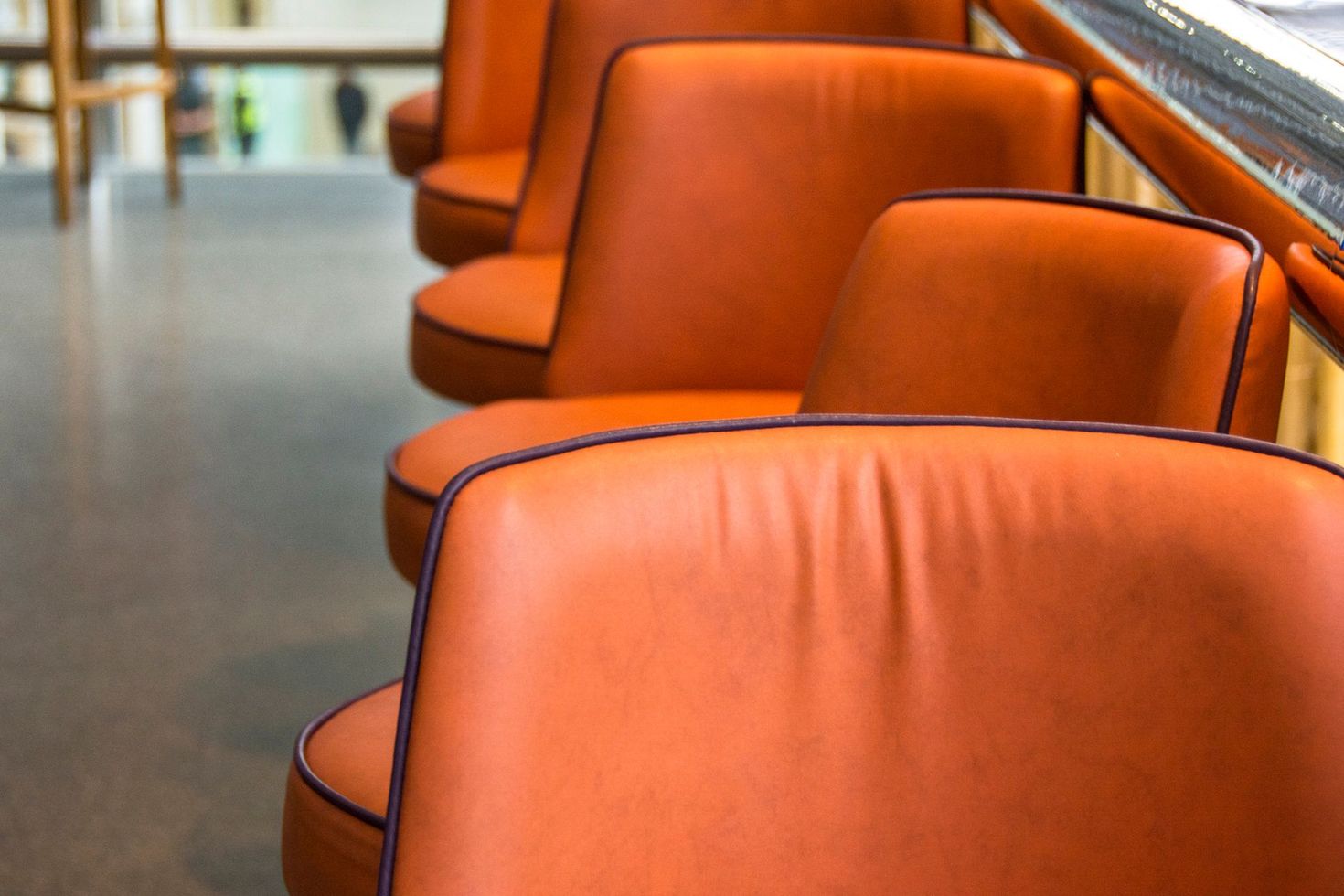 Orange leather chairs in a row in a modern waiting area