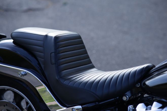 Black stitched motorcycle seat with chrome trim and rear fender detail