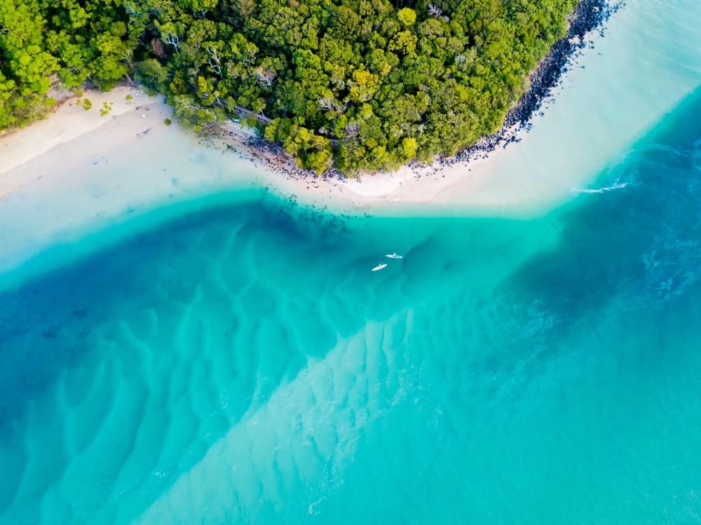 An Aerial View Of A Small Island In The Middle Of The Ocean Surrounded By Trees — Strait Edge Painting In Gold Coast, NSW
