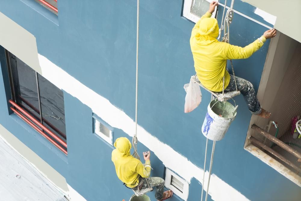 Two Men Are Painting A Building From A Rope — Strait Edge Painting In Tweed Heads South, NSW