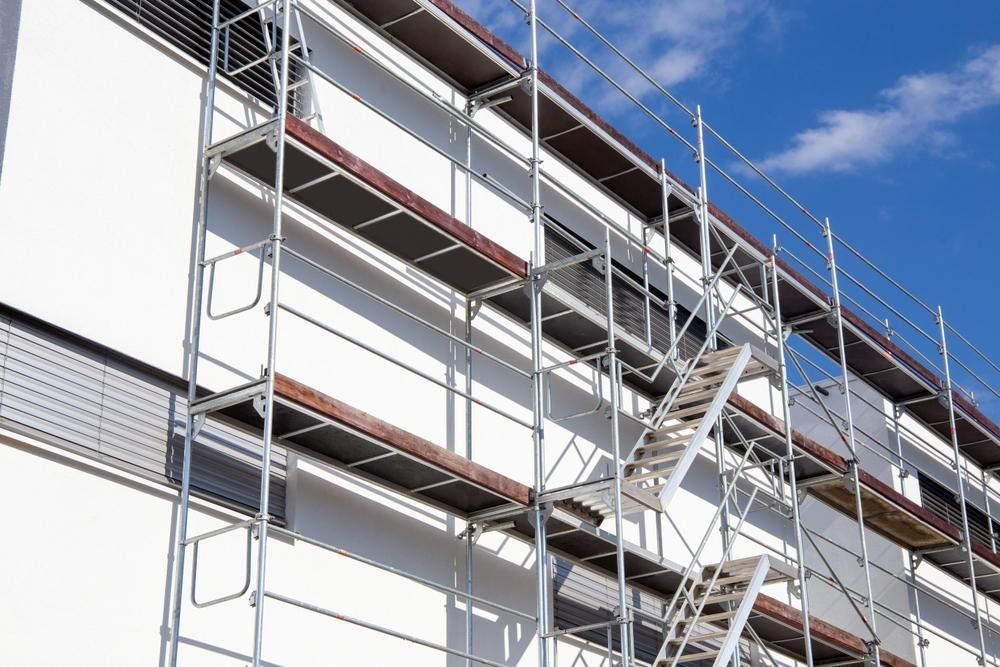 A Building Is Being Painted With Scaffolding And Stairs — Strait Edge Painting In Byron Bay, NSW