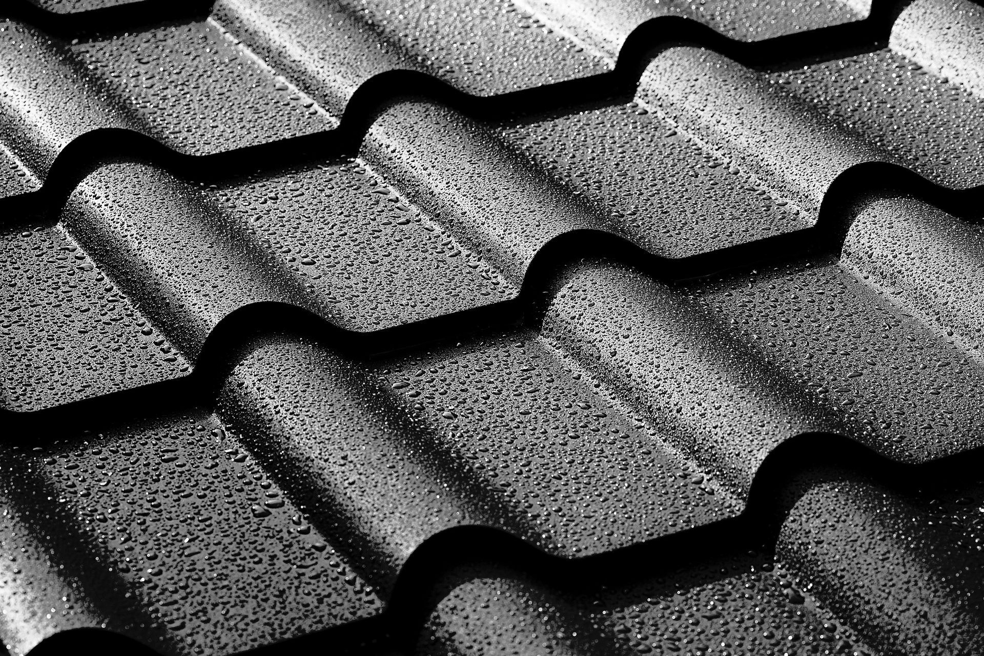 A Close-up of Dark Grey, Textured Metal Roofing Tiles — Strait Edge Painting In Tweed Heads South, NSW