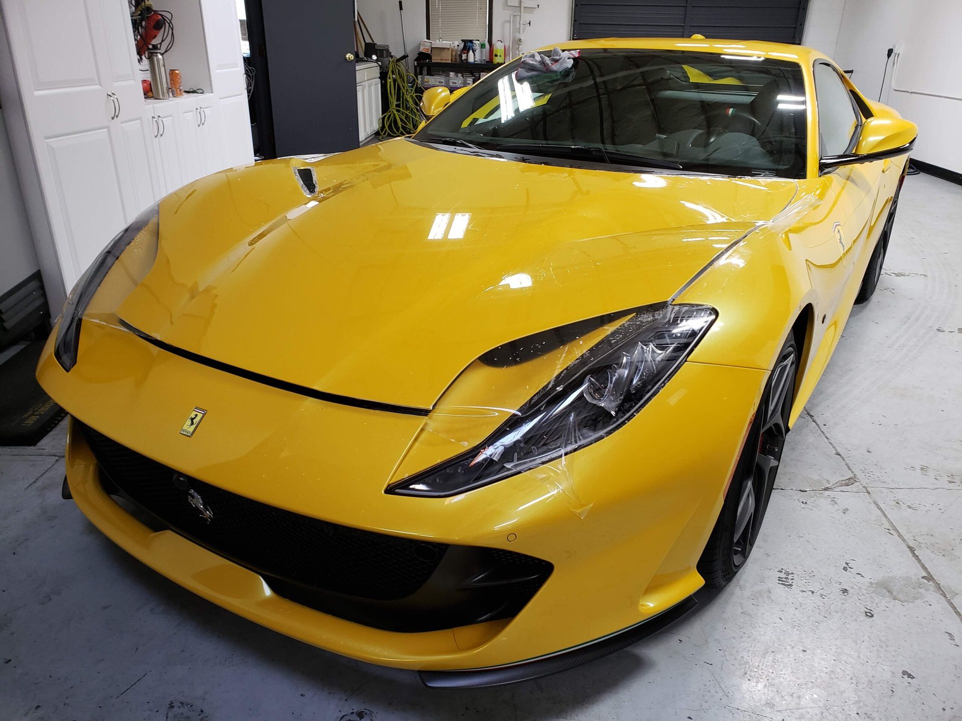 Yellow sports car parked indoors in a garage, angled front view