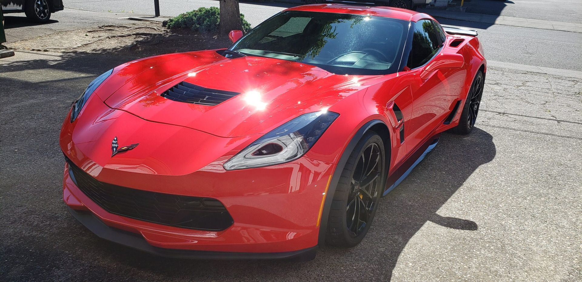 Red sports car parked outdoors in a parking lot, front view