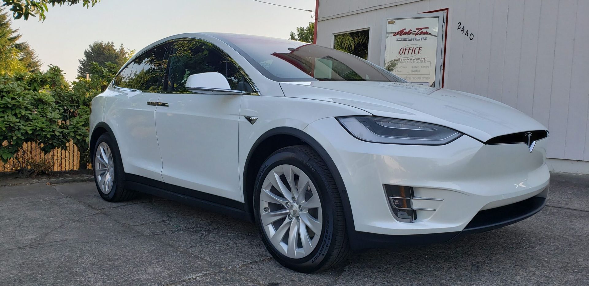 White Tesla SUV parked outdoors beside a building