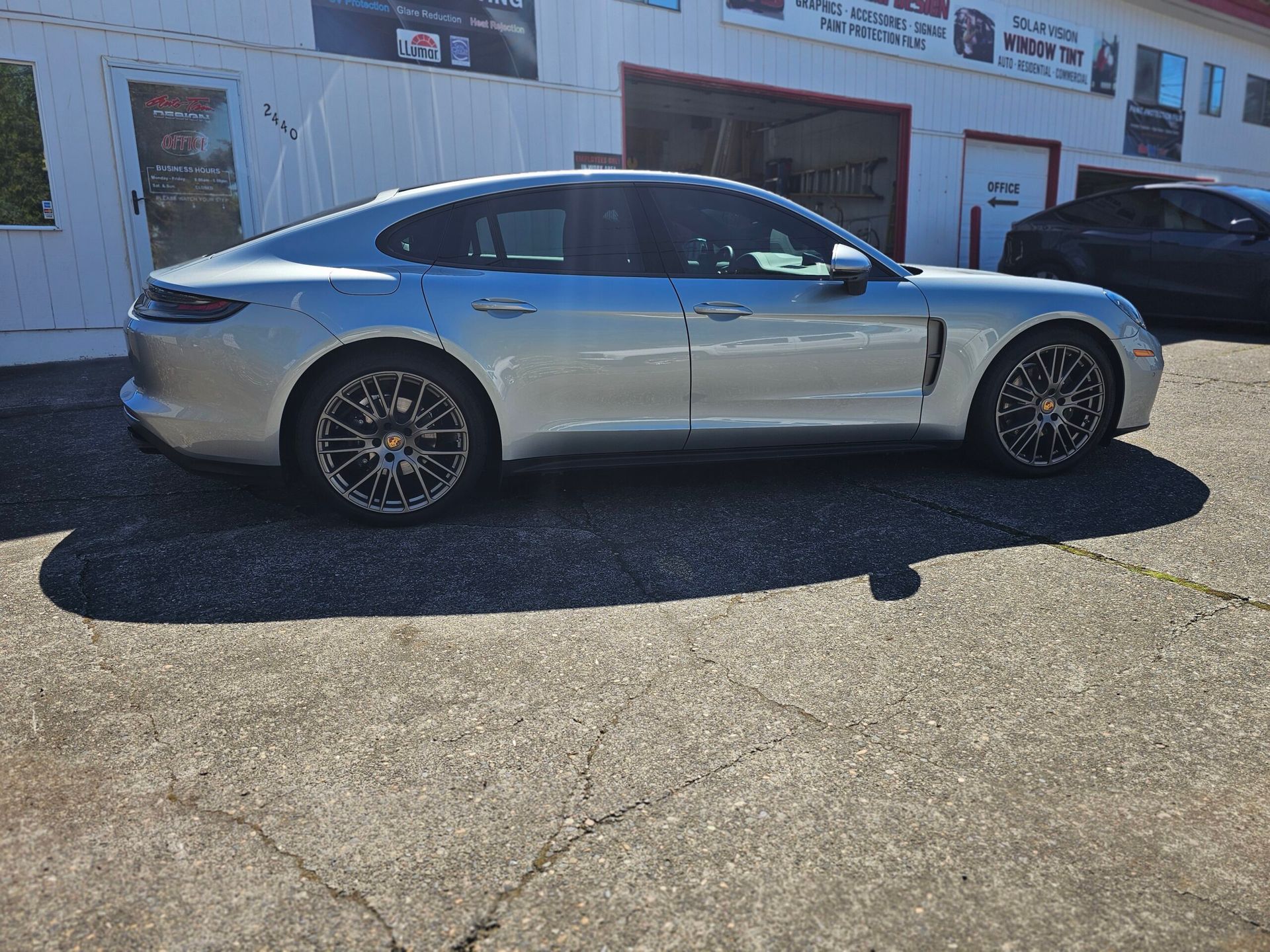 Silver sedan parked outside a dealership on a sunny day