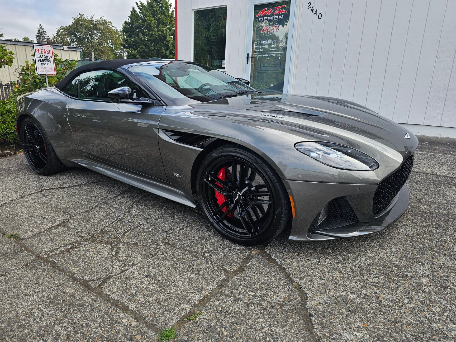 Gray sports coupe parked outdoors, side view with black wheels and red brake calipers
