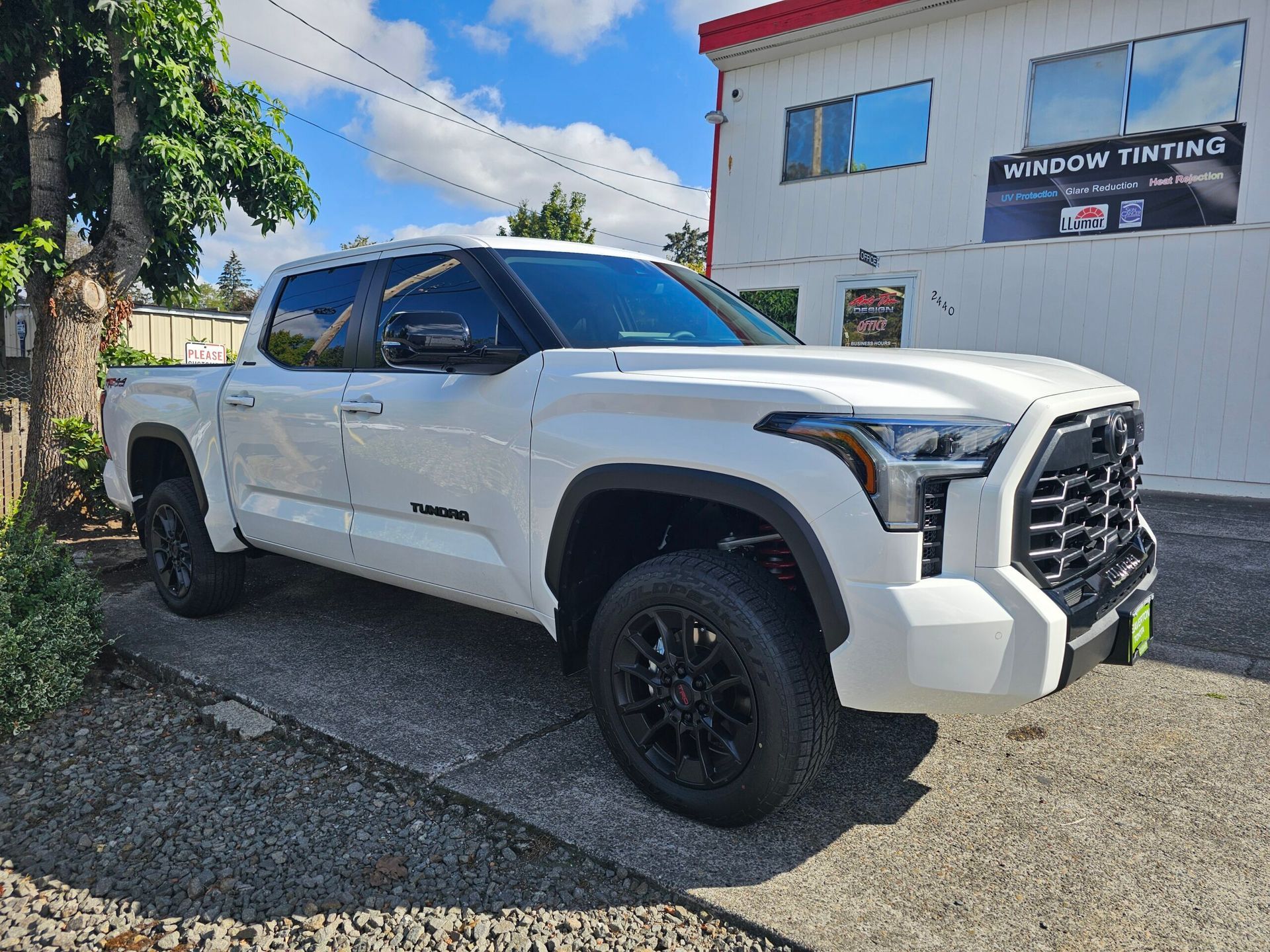 White GMC pickup truck parked outside a building on a sunny day