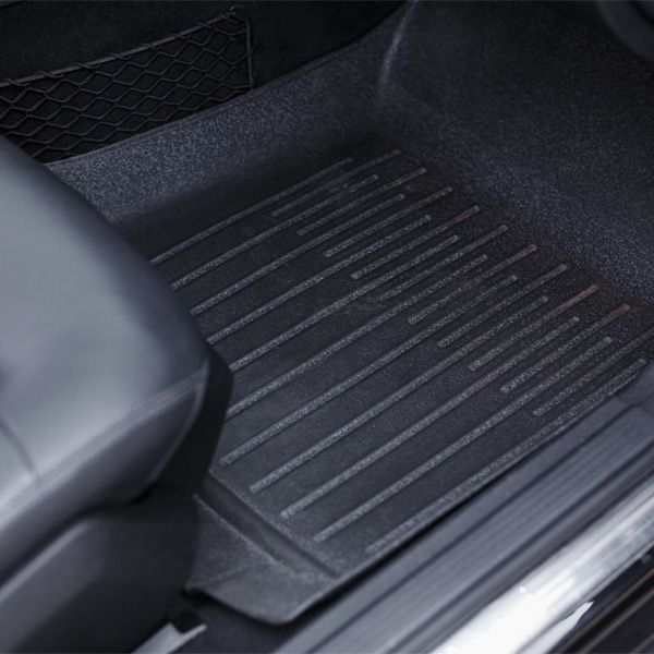 Black rubber car floor mat with ridged texture on the passenger side floor.