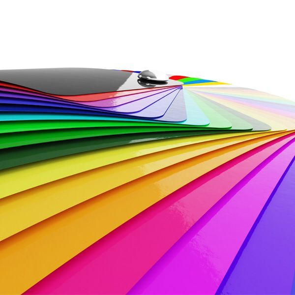 Rainbow fan of colorful folded paper swatches with a metal binder clip on top