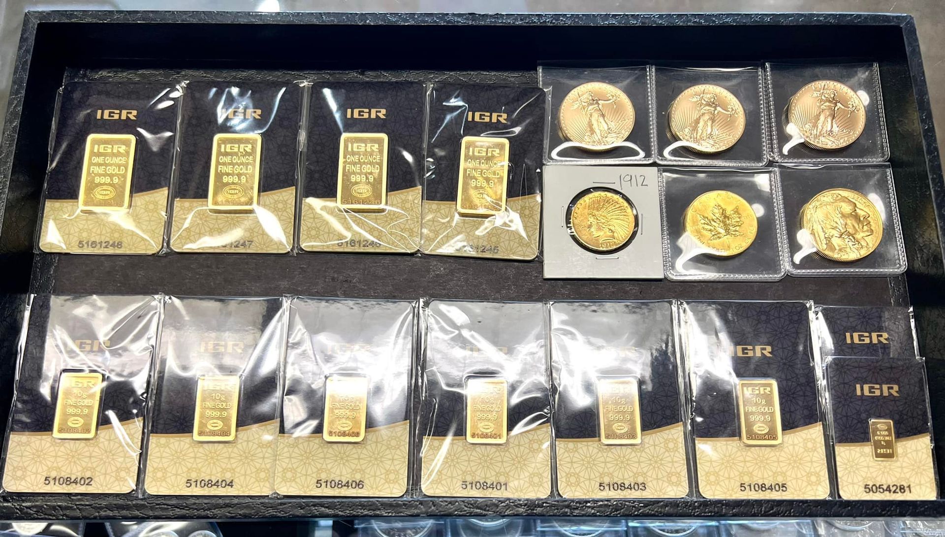A tray of gold bars and coins with the word italy on them