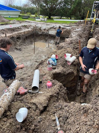 A Group of Men Are Digging a Hole in the Dirt — Wello's Plumbing & Gas In Thurgoona, NSW