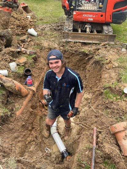 Two Men Are Working on a Brick Wall — Wello's Plumbing & Gas In Thurgoona, NSW
