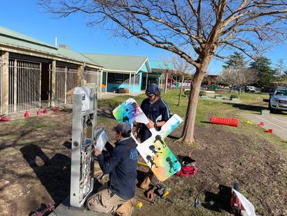 Two Men Are Working on a Fence in a Park — Wello's Plumbing & Gas In Thurgoona, NSW