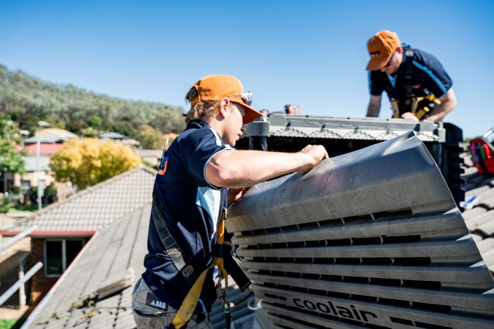 Two Men Are Working on The Roof of A House — Wello's Plumbing & Gas in Thurgoona, NSW