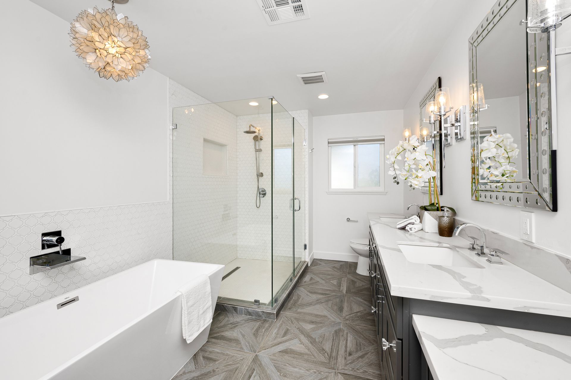Bright modern bathroom with freestanding tub, glass shower, vanity, and large mirror