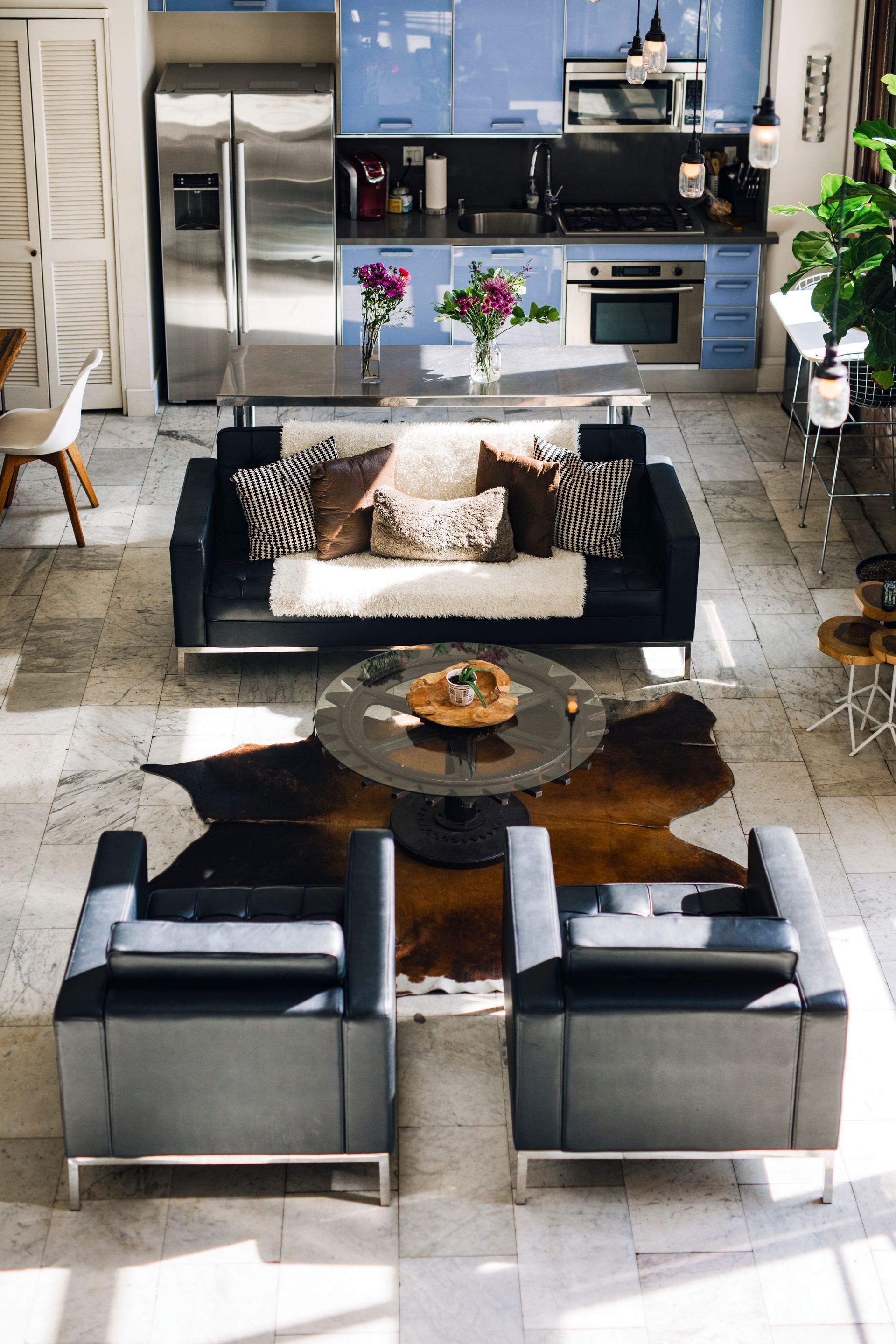 Modern outdoor patio with gray sectional seating, coffee table, and kitchen area in the background