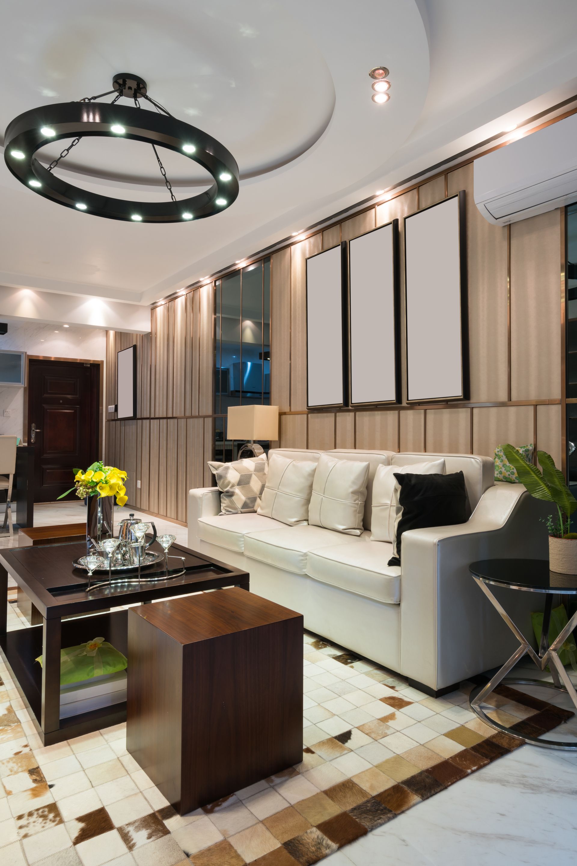 Modern living room with white sofa, dark coffee table, pendant light, and striped curtains