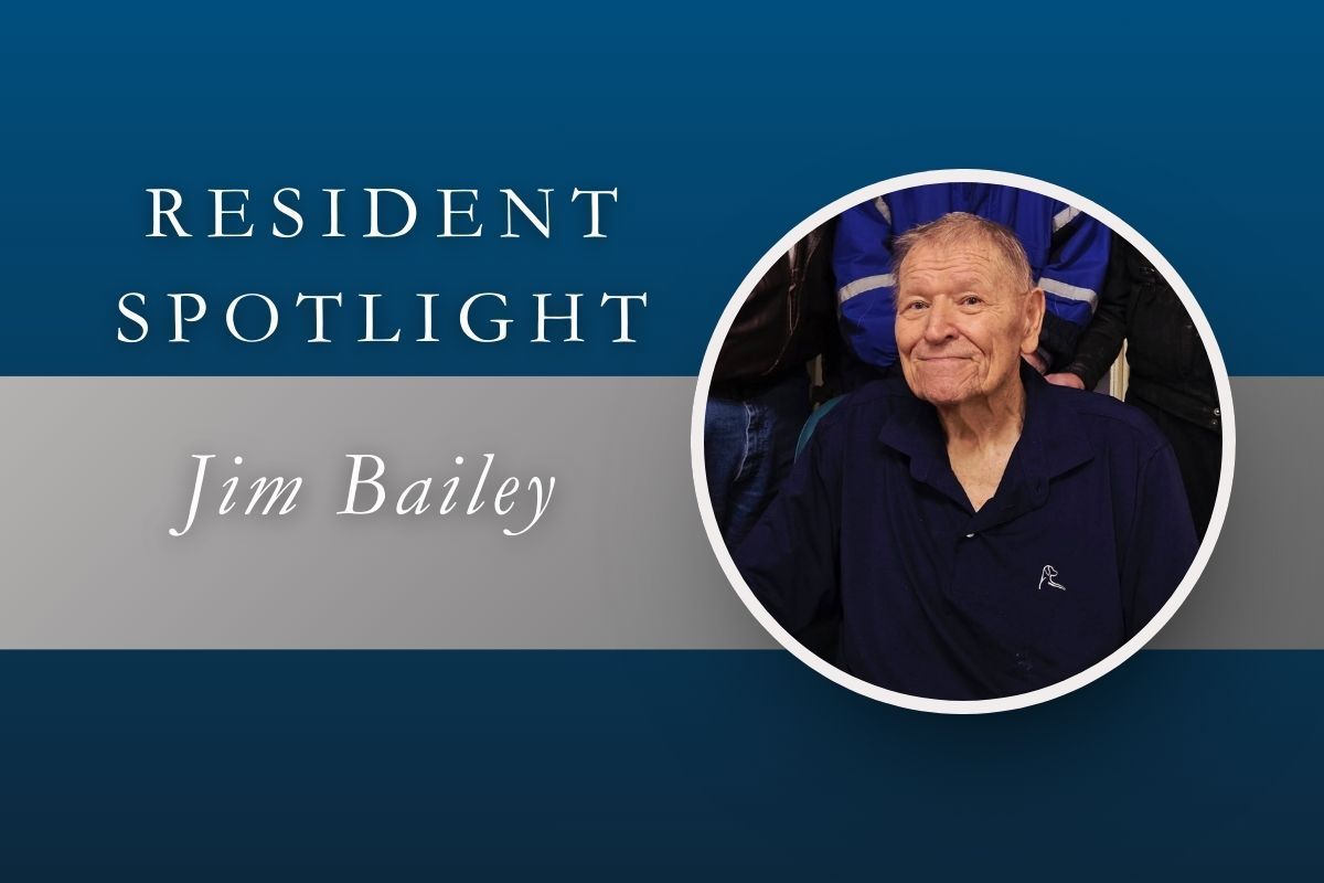 Resident Spotlight: Jim Bailey, senior man in a blue shirt smiling.