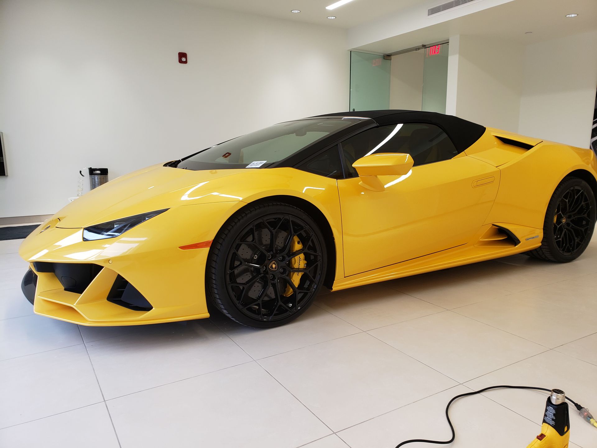A yellow lamborghini huracan is parked in a garage.
