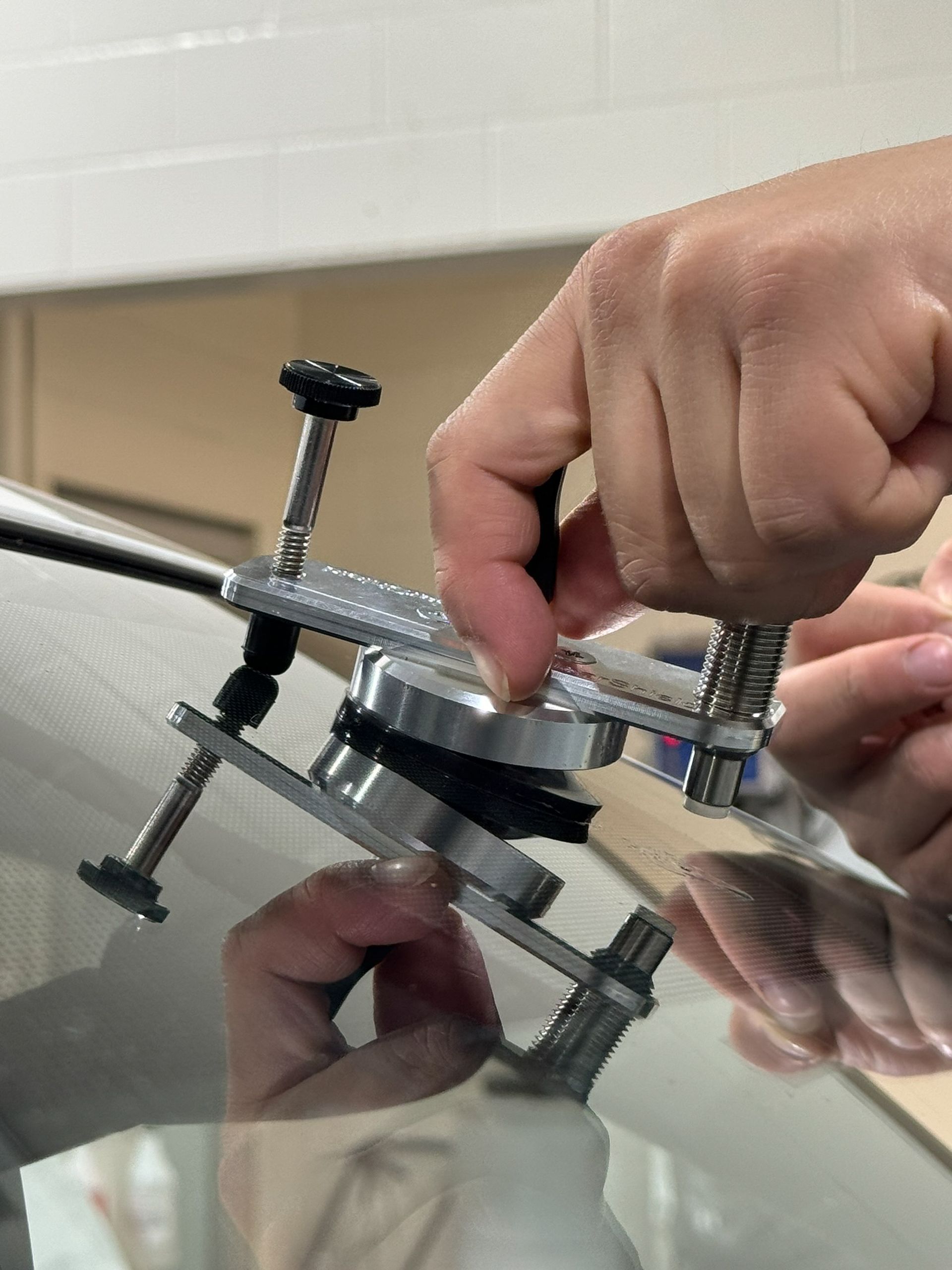 A person is repairing a windshield with a tool.