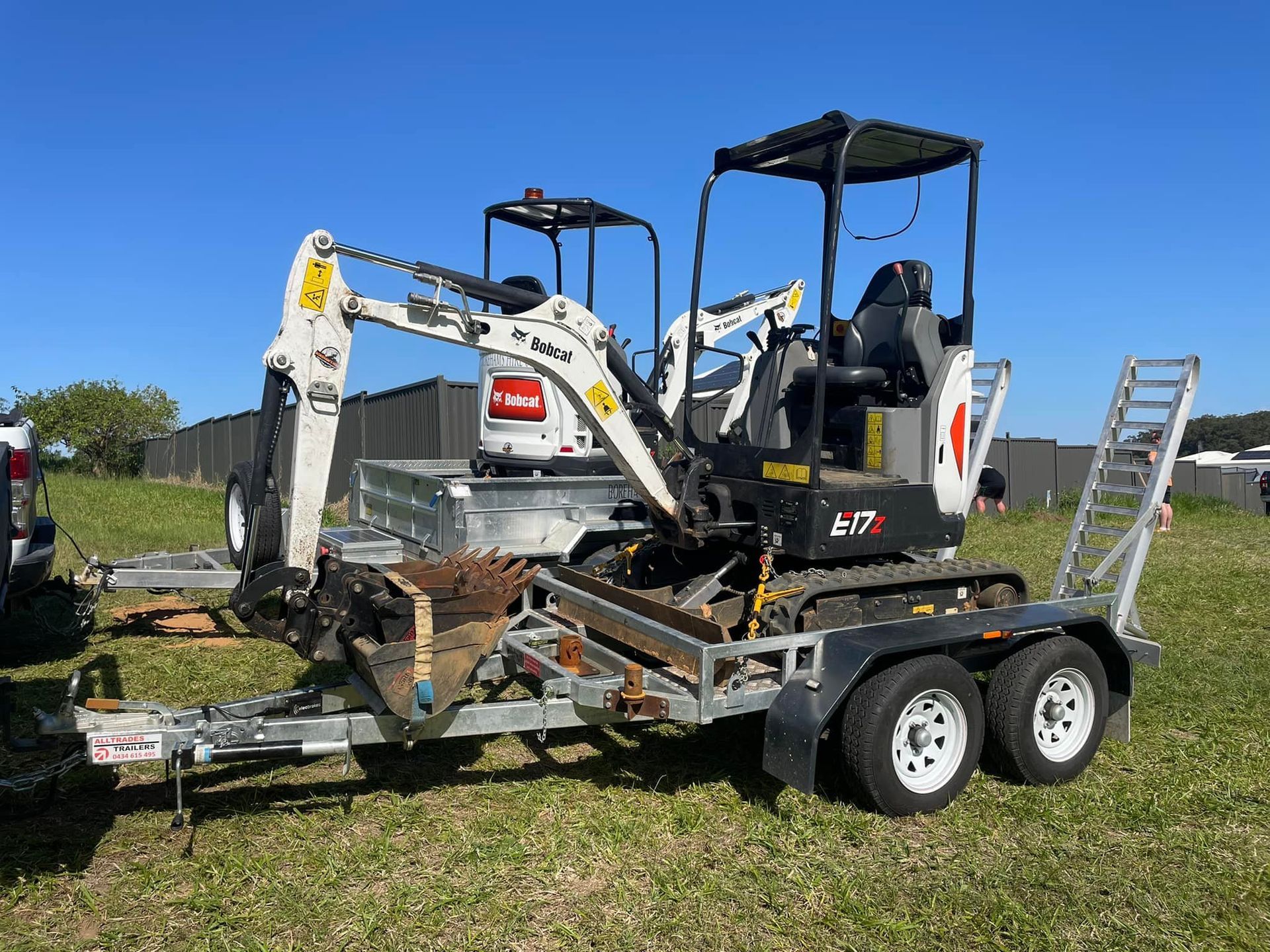Mini-excavator on a Trailer in a Grassy Field — Borehams Hire In Meridan Plains, QLD