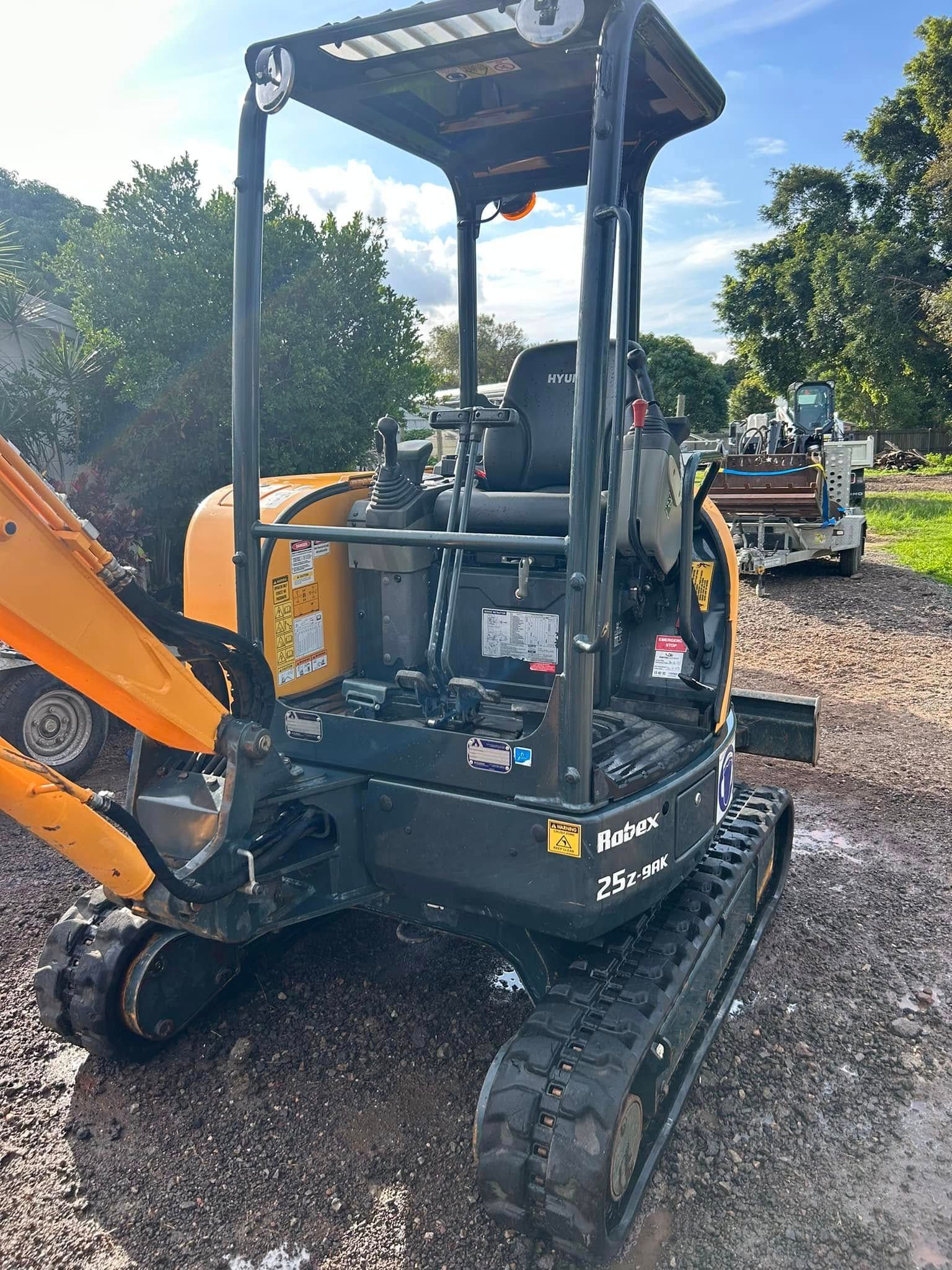 Yellow and Black Mini Excavator Outdoors on a Cloudy Day — Borehams Hire In Meridan Plains, QLD