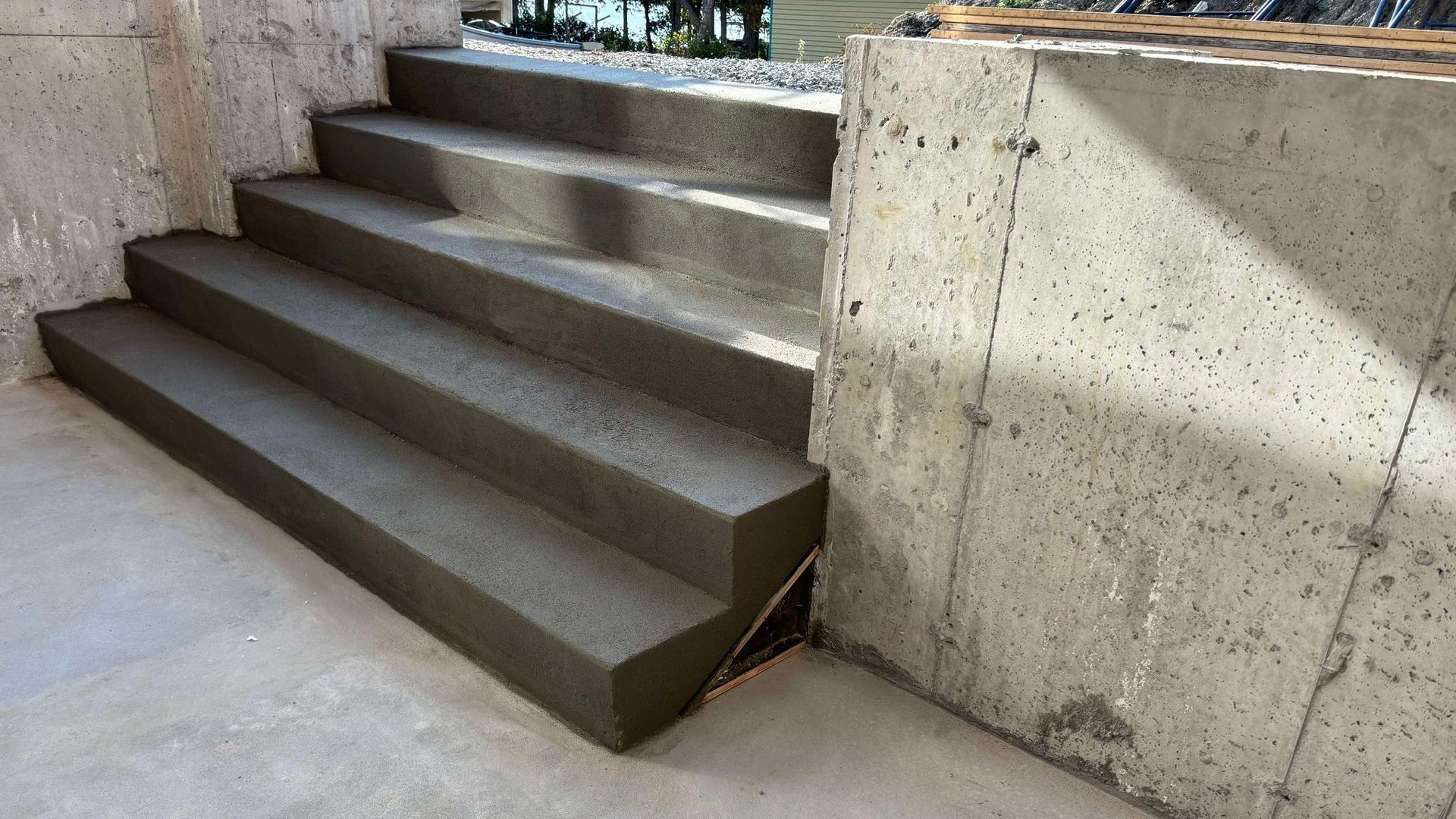 Escalier en béton menant vers le haut, à côté d'un mur en béton.