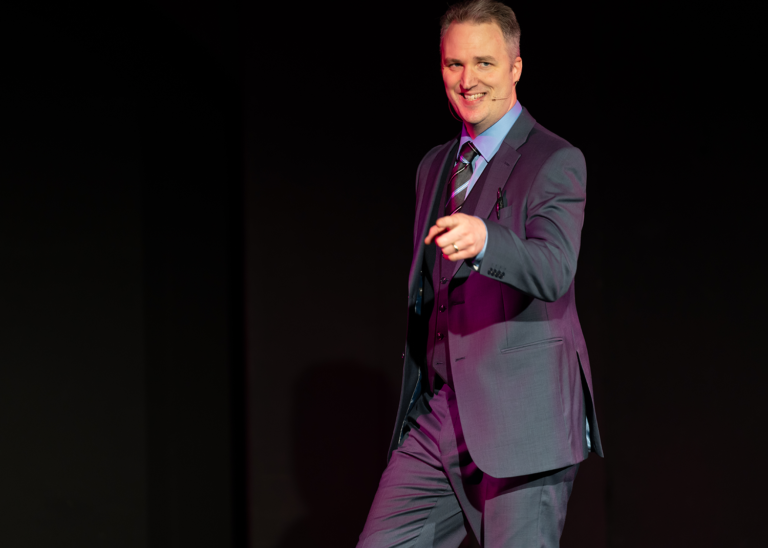 A man in a suit and tie is standing on a stage.