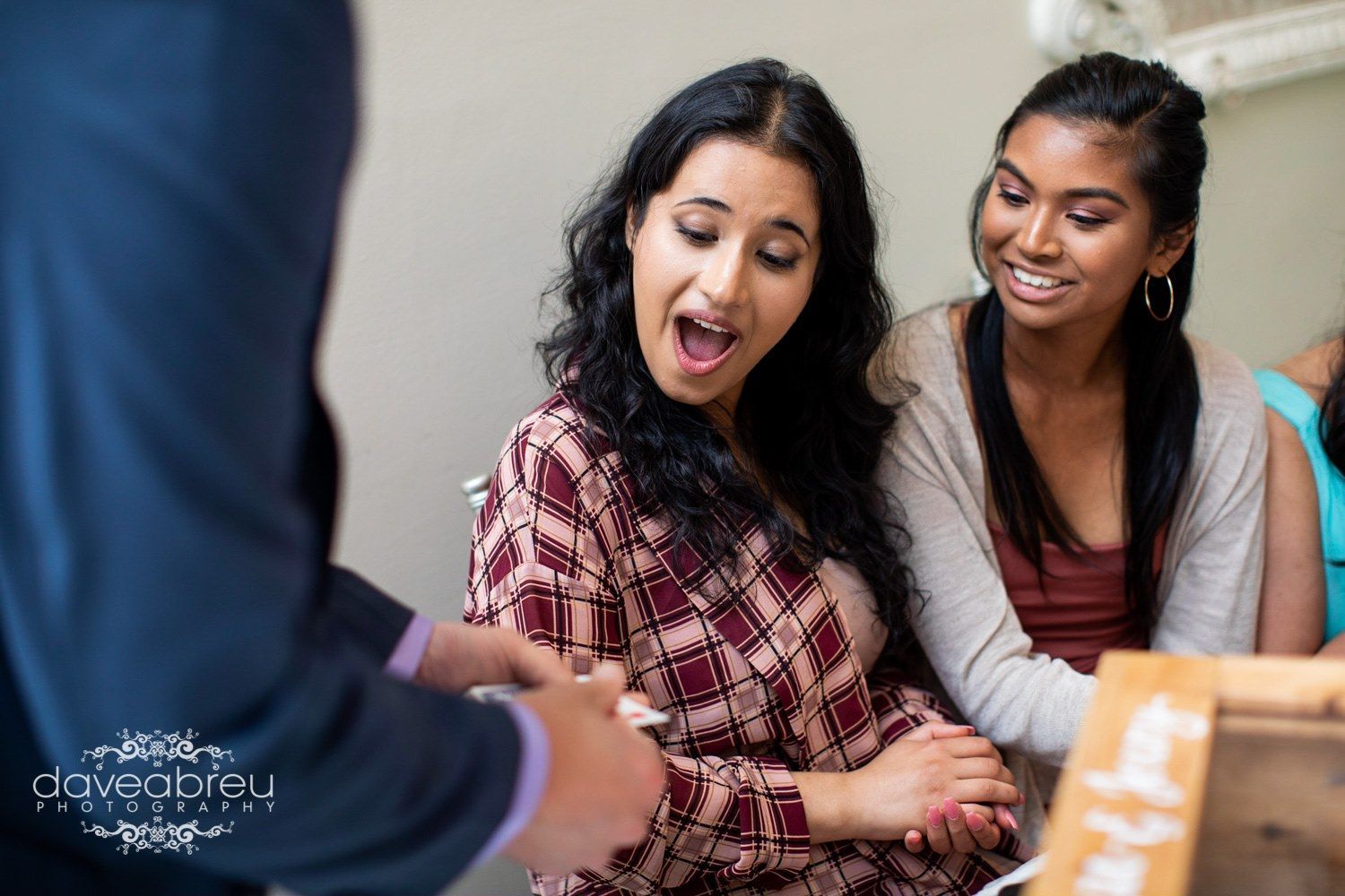 A group of young women are sitting around a table looking at something.