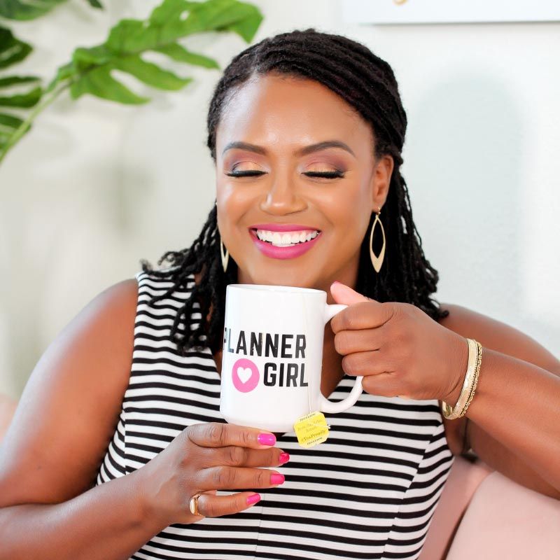 Dr. Franchelle Caesar, The Life Coach for High-Achieving Women, smiling and drinking from a Planner Girl mug