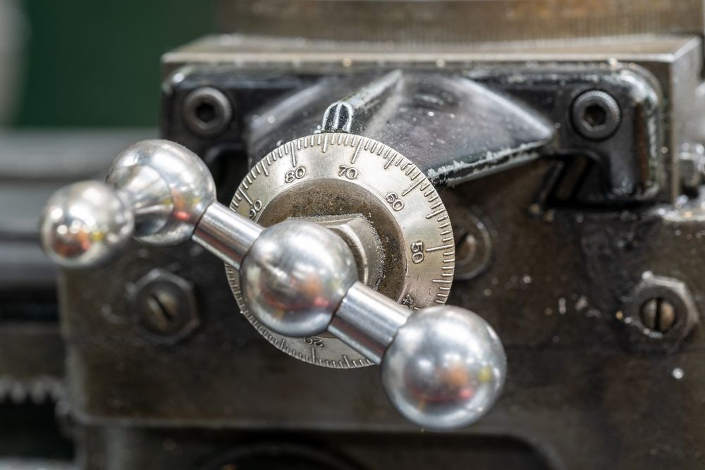 Close-up of a metal lathe handwheel with a numbered dial.