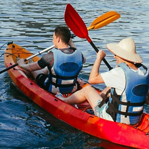 Un hombre y una mujer están remando en kayak en un lago.