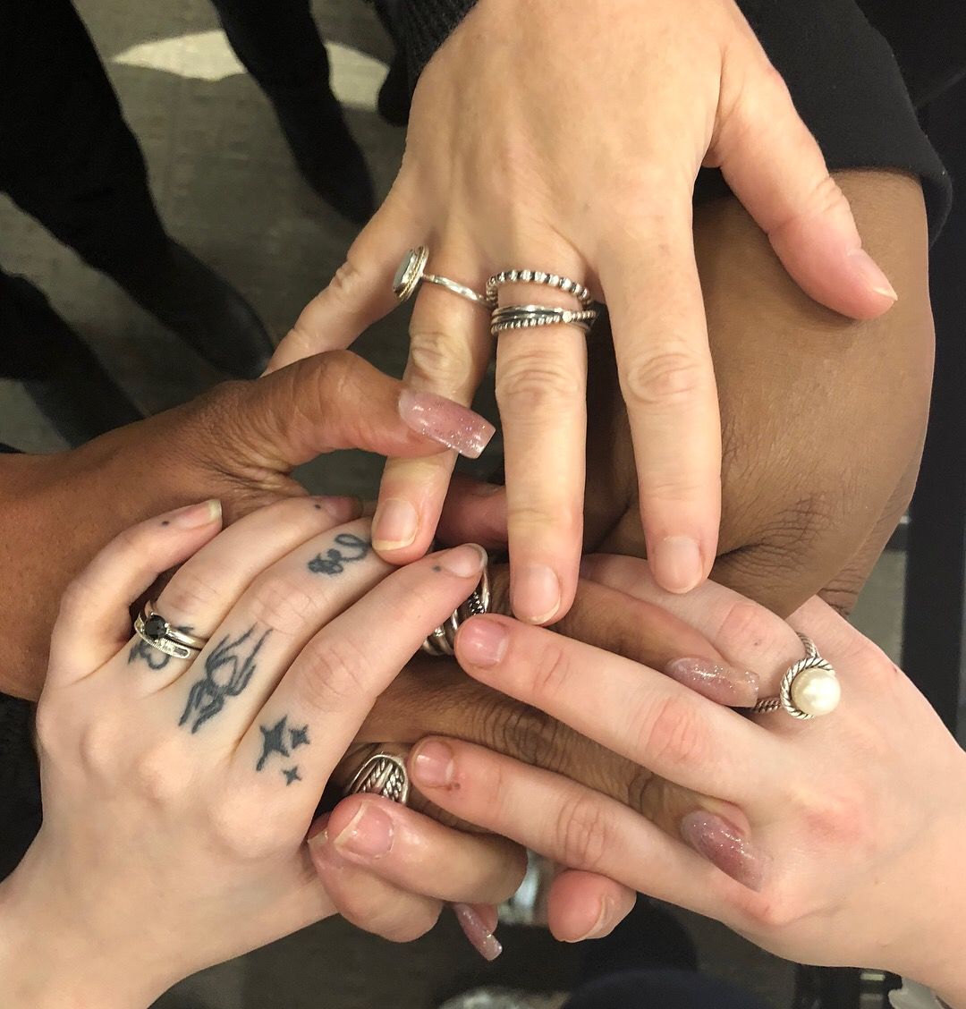 diverse women holding hands in support of each other
