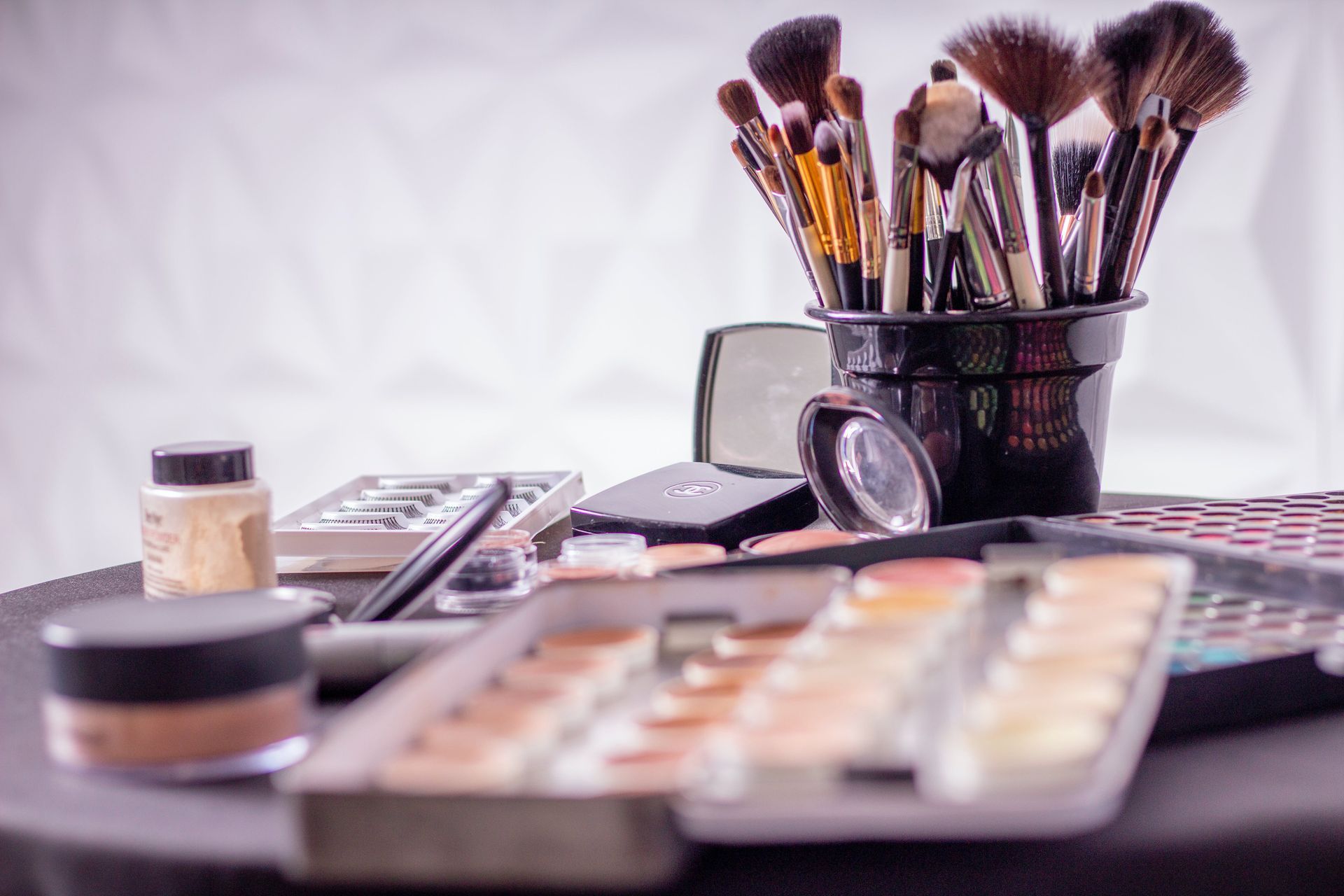 Makeup brushes and cosmetics arranged on a vanity table.