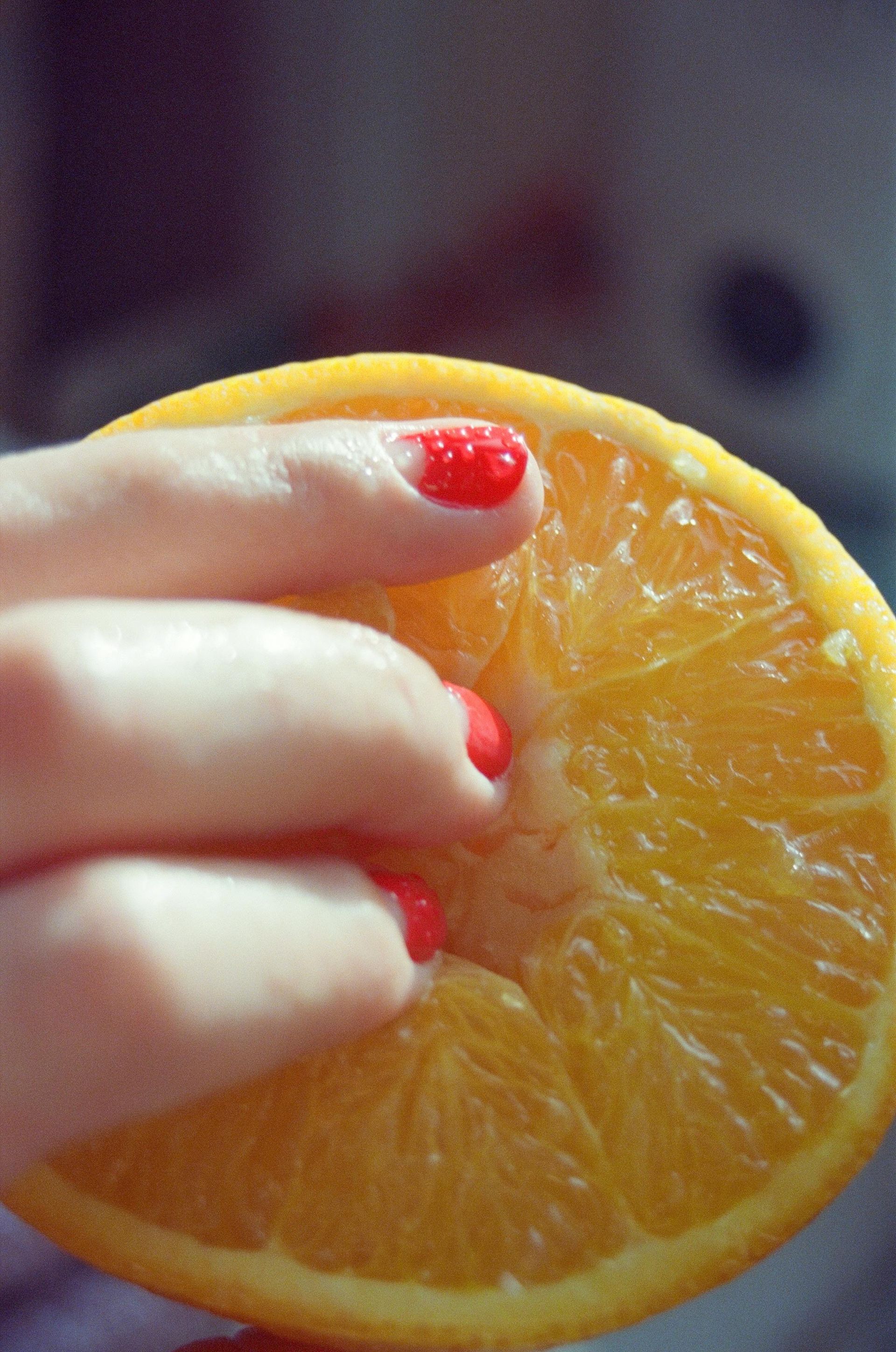 woman with orange nail polish